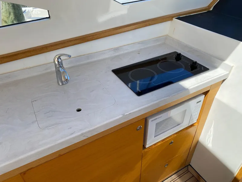 Slide: The Image of Modern kitchen area in a 2018 Custom Emerald Bay 36 yacht with stove and microwave. - 17