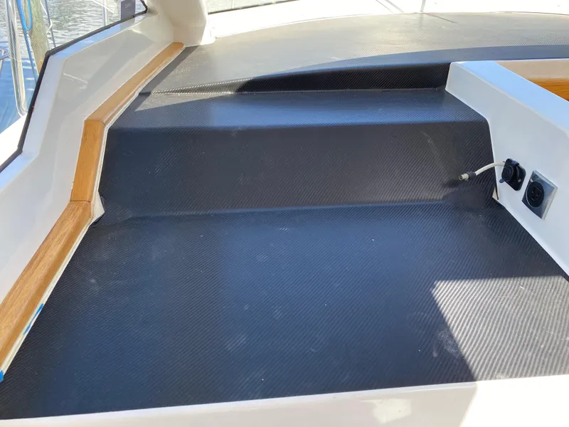 Slide: The Image of 2018 Custom Emerald Bay 36 boat interior with black non-slip flooring and wooden trim. - 19