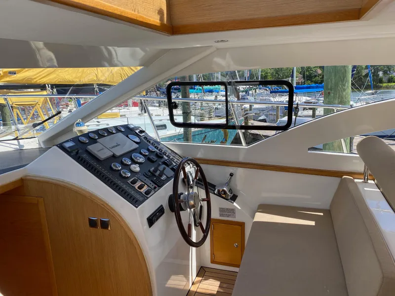 Slide: The Image of Interior helm of 2018 Custom Emerald Bay 36 yacht with wooden accents and marina view. - 20