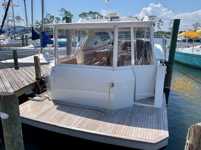 Slide: The Image of Custom Emerald Bay 36 (2018) docked at marina with clear enclosure. - 4