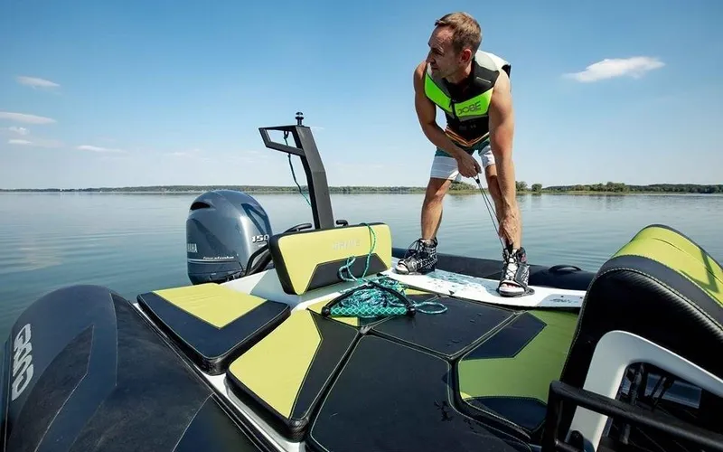 Slide: The Image of Man preparing for water sports on a 2024 Grand D600 boat. - 12