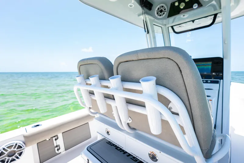 Slide: The Image of 2024 Sportsman Masters 247 Bay Boat interior with rod holders and ocean view. - 24