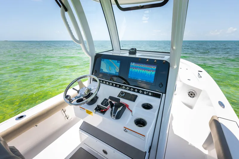 Slide: The Image of 2024 Sportsman Masters 247 Bay Boat dashboard with dual screens on open water. - 9