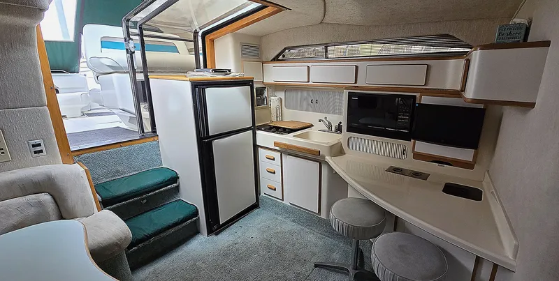Slide: The Image of Interior of 1992 Sea Ray 400 Express Cruiser with kitchenette and seating area. - 2
