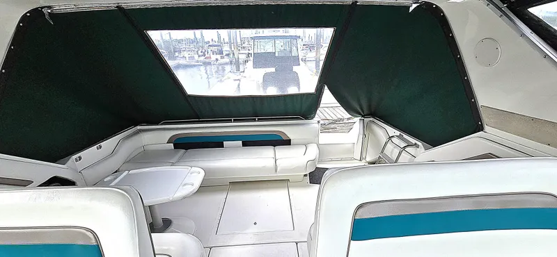 Slide: The Image of 1992 Sea Ray 400 Express Cruiser interior with white seating and marina view. - 4