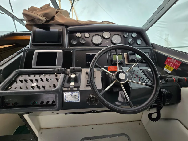 Slide: The Image of 1992 Sea Ray 400 Express Cruiser helm with steering wheel and control panels. - 6