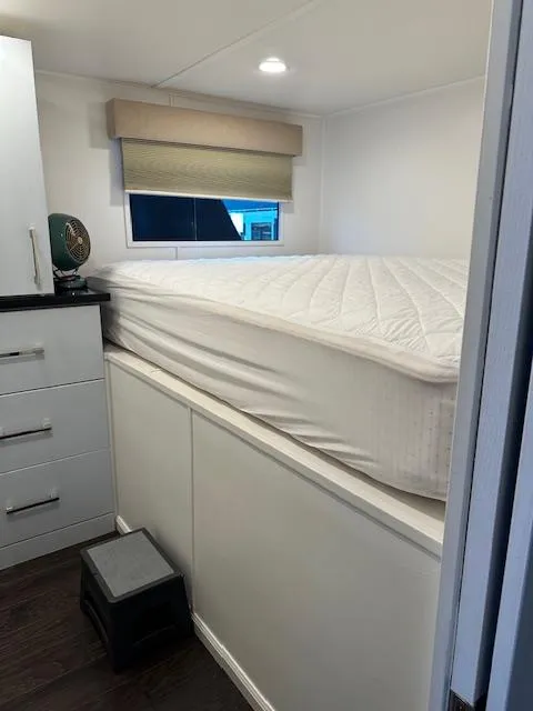 Slide: The Image of Interior of 1992 Jamestowner Silver Lining houseboat with elevated bed and storage. - 4