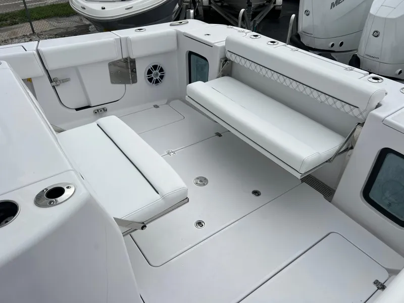 Slide: The Image of 2024 Sportsman Open 352 boat interior with white cushioned seating and storage compartments. - 15