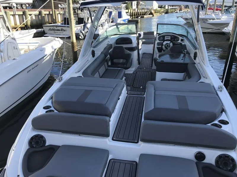 Slide: The Image of 2020 Rinker 29QX BR boat with spacious seating docked at a marina. - 11