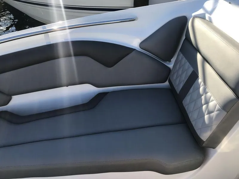 Slide: The Image of 2020 Rinker 29QX BR boat interior with gray and black cushioned seating. - 16