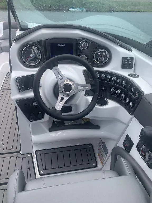 Slide: The Image of 2020 Rinker 29QX BR boat dashboard with steering wheel and control panel. - 19