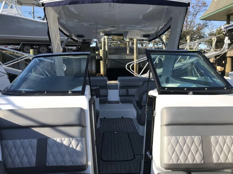 Slide: The Image of 2020 Rinker 29QX BR boat interior with gray seating and open cockpit. - 25