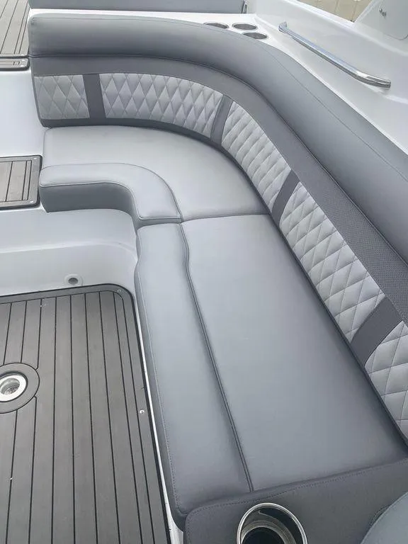 Slide: The Image of 2020 Rinker 29QX BR boat with gray cushioned seating and diamond stitching. - 26