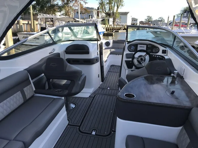 Slide: The Image of 2020 Rinker 29QX BR boat interior with seating, steering wheel, and dashboard. - 29