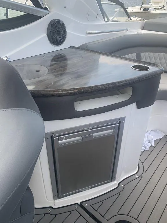 Slide: The Image of 2020 Rinker 29QX BR boat interior with mini fridge and countertop. - 7