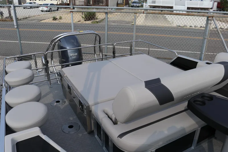 Slide: The Image of 2023 Sylvan L5 DLZ Bar pontoon boat with seating and motor, docked near a fence. - 11
