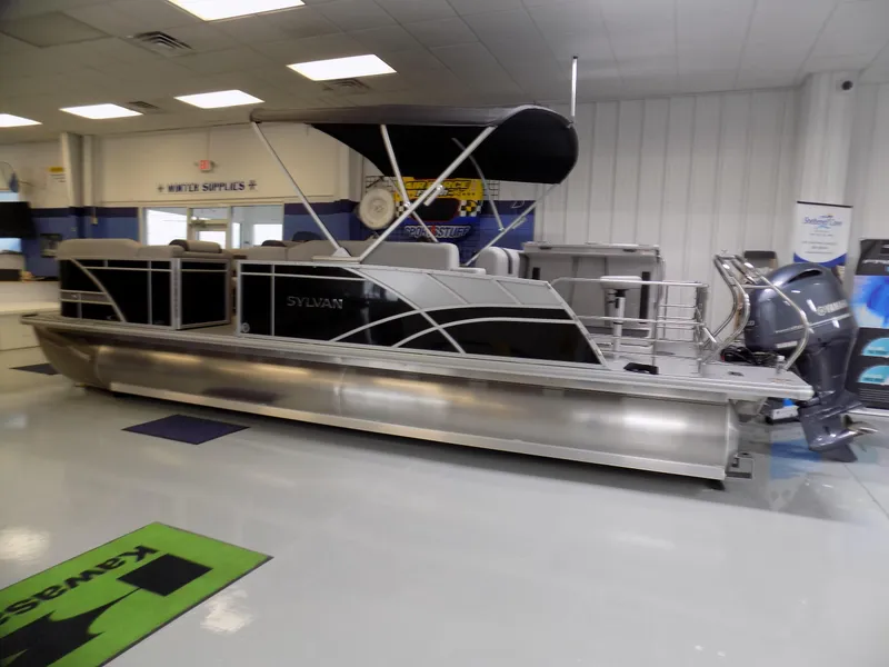 Slide: The Image of 2023 Sylvan L5 DLZ Bar pontoon boat displayed indoors with modern design and features. - 2