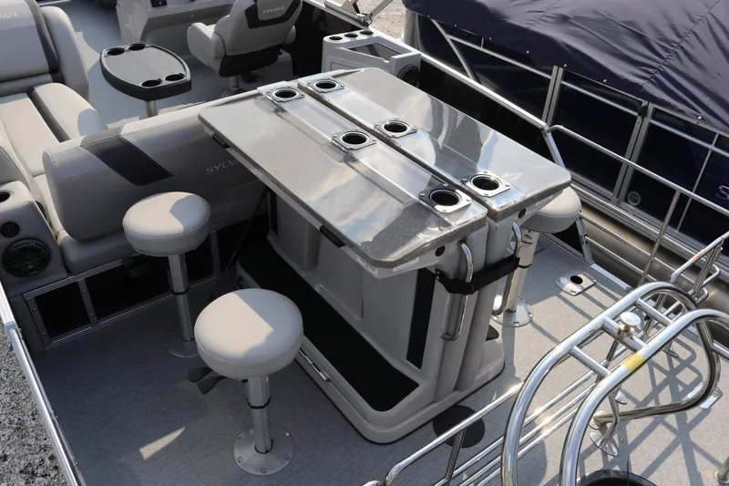 Slide: The Image of 2023 Sylvan L5 DLZ Bar pontoon boat interior with bar seating and cup holders. - 8