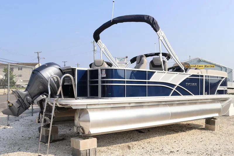 Slide: The Image of 2023 Sylvan L3 Party Fish pontoon boat with outboard motor, displayed on blocks. - 3