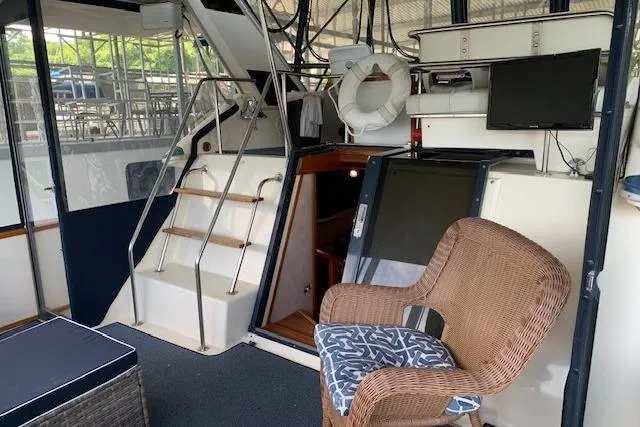 Slide: The Image of 1987 Sea Ray 410 Aft Cabin interior with wicker chair, stairs, and mounted TV. - 10