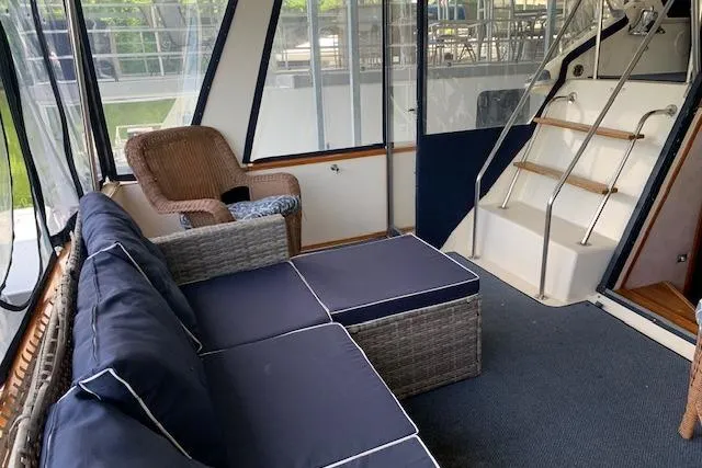 Slide: The Image of 1987 Sea Ray 410 Aft Cabin interior with wicker seating and navy cushions. - 11