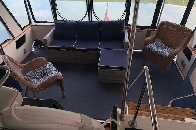 Slide: The Image of 1987 Sea Ray 410 Aft Cabin interior with wicker seating and blue cushions. - 12