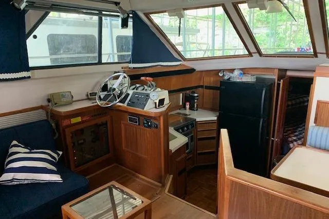 Slide: The Image of 1987 Sea Ray 410 Aft Cabin interior with helm, kitchen, and seating area. - 16