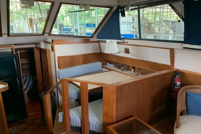 Slide: The Image of 1987 Sea Ray 410 Aft Cabin interior with wood paneling and seating area. - 17