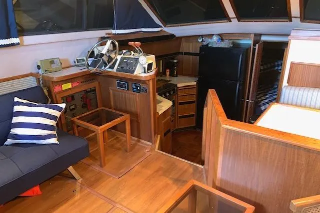 Slide: The Image of 1987 Sea Ray 410 Aft Cabin interior with helm, kitchen, and seating area. - 18