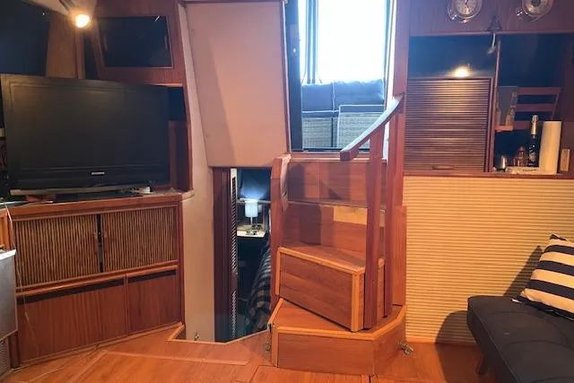 Slide: The Image of Interior of 1987 Sea Ray 410 Aft Cabin with wooden stairs and cozy living area. - 19