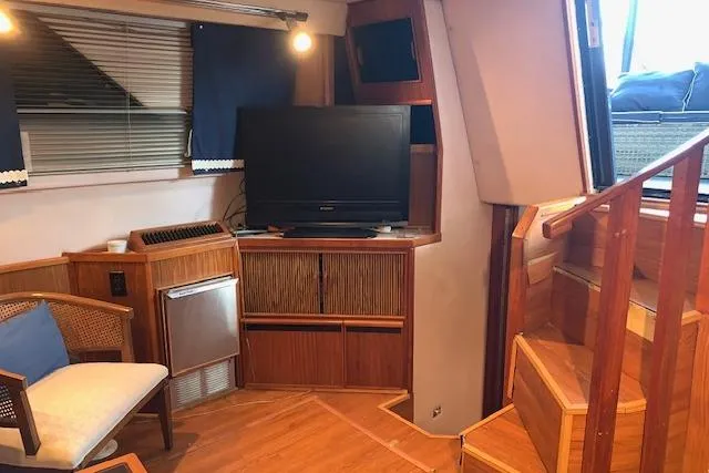 Slide: The Image of 1987 Sea Ray 410 Aft Cabin interior with TV, wooden cabinetry, and stairs. - 20