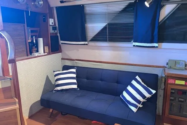 Slide: The Image of Interior of 1987 Sea Ray 410 Aft Cabin with blue sofa and striped pillows. - 21