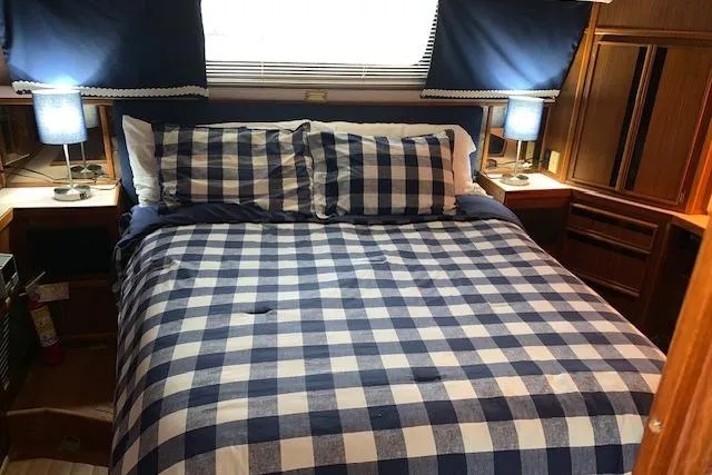 Slide: The Image of Cozy bedroom in 1987 Sea Ray 410 Aft Cabin with checkered bedding and blue lamps. - 22