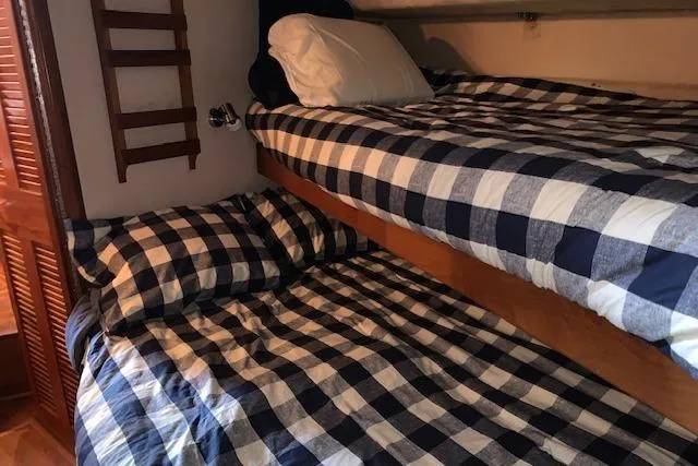 Slide: The Image of Bunk beds with checkered bedding in 1987 Sea Ray 410 Aft Cabin yacht. - 27
