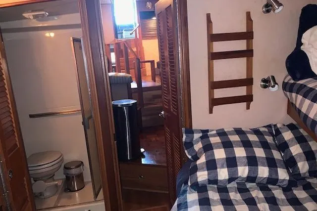 Slide: The Image of 1987 Sea Ray 410 Aft Cabin interior with cozy bedroom and bathroom. - 28