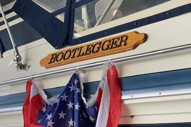 Slide: The Image of 1987 Sea Ray 410 Aft Cabin boat named "Bootlegger" with American flag. - 8