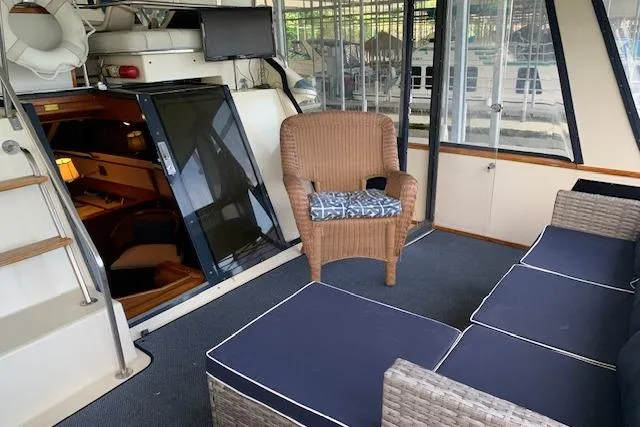 Slide: The Image of 1987 Sea Ray 410 Aft Cabin interior with wicker seating and nautical decor. - 9