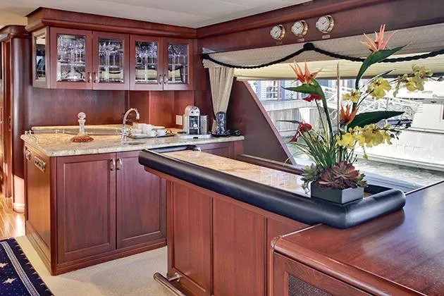 Slide: The Image of Luxurious yacht interior with wooden cabinets, bar, and floral arrangement. - 26