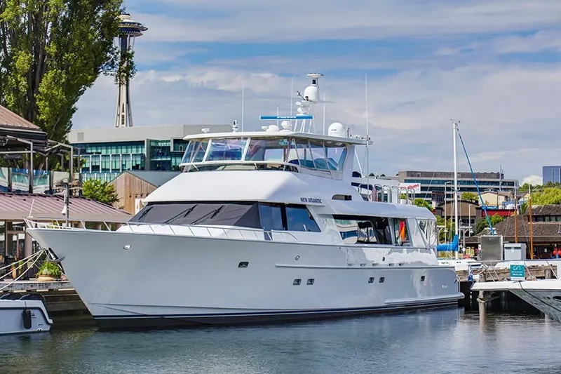 Slide: The Image of A luxury motor yacht docked in a harbor with a tower in the background. - 2