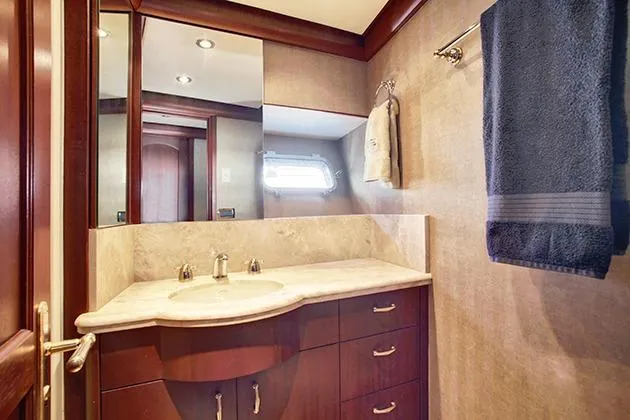 Slide: The Image of Luxurious bathroom with wooden cabinets, marble sink, and towel rack. - 45