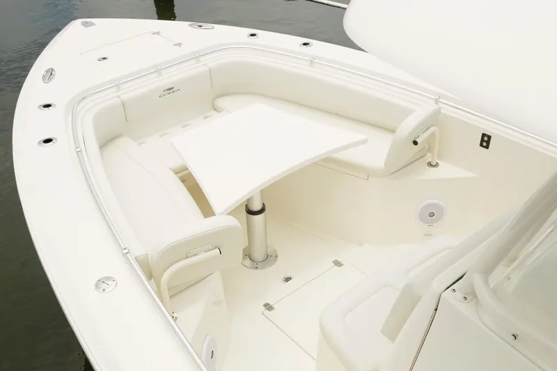 Slide: The Image of 2024 Cobia 301 CC boat with white seating and table in bow area. - 2