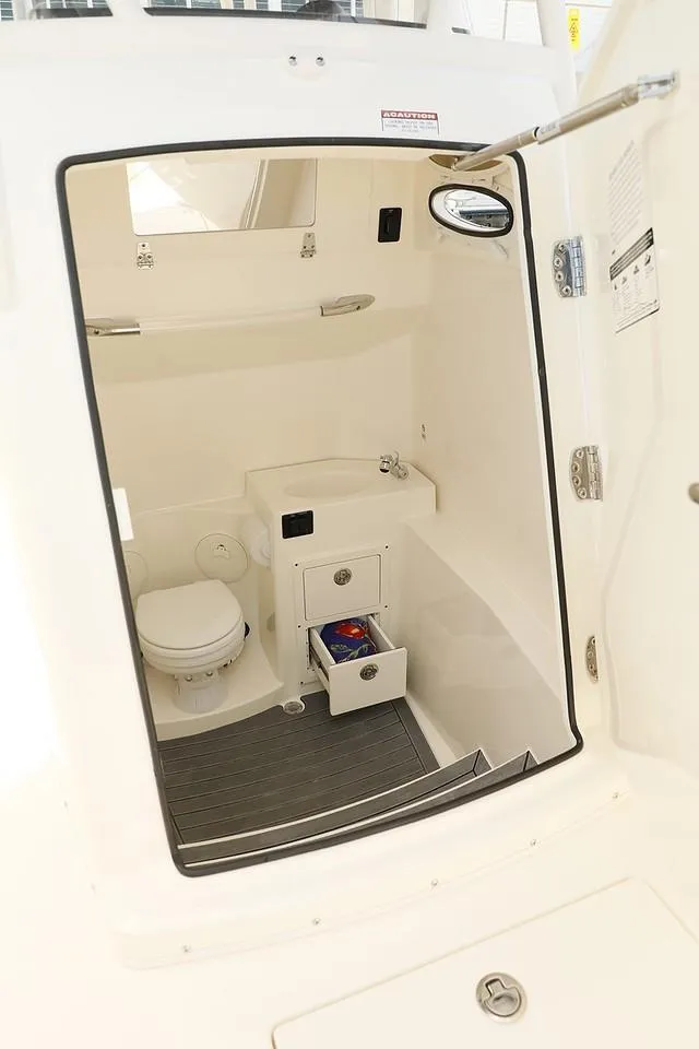 Slide: The Image of 2024 Cobia 301 CC boat interior with toilet and sink. - 6