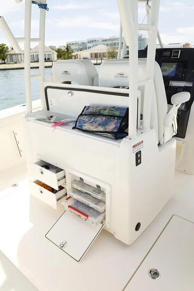 Slide: The Image of 2024 Cobia 301 CC center console with storage compartments and fishing gear. - 9