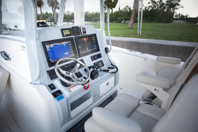 Slide: The Image of 2024 Cobia 320 CC boat cockpit with advanced navigation system and comfortable seating. - 11