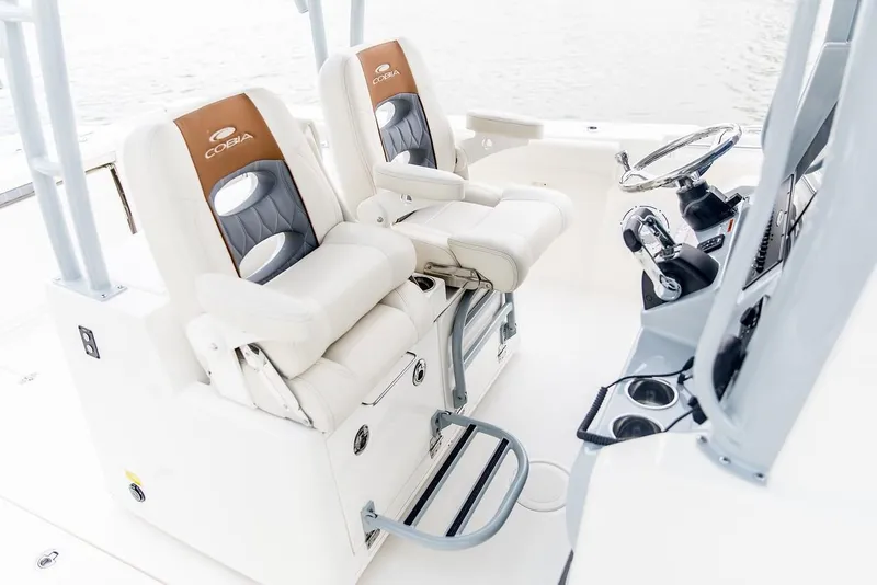 Slide: The Image of 2024 Cobia 320 CC boat interior with dual captain's chairs and helm station. - 5