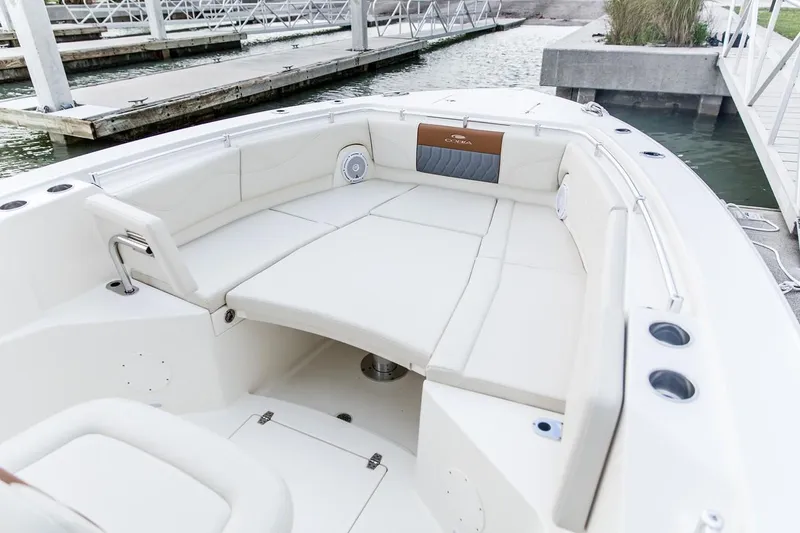 Slide: The Image of 2024 Cobia 320 CC boat with spacious seating at the dock. - 7
