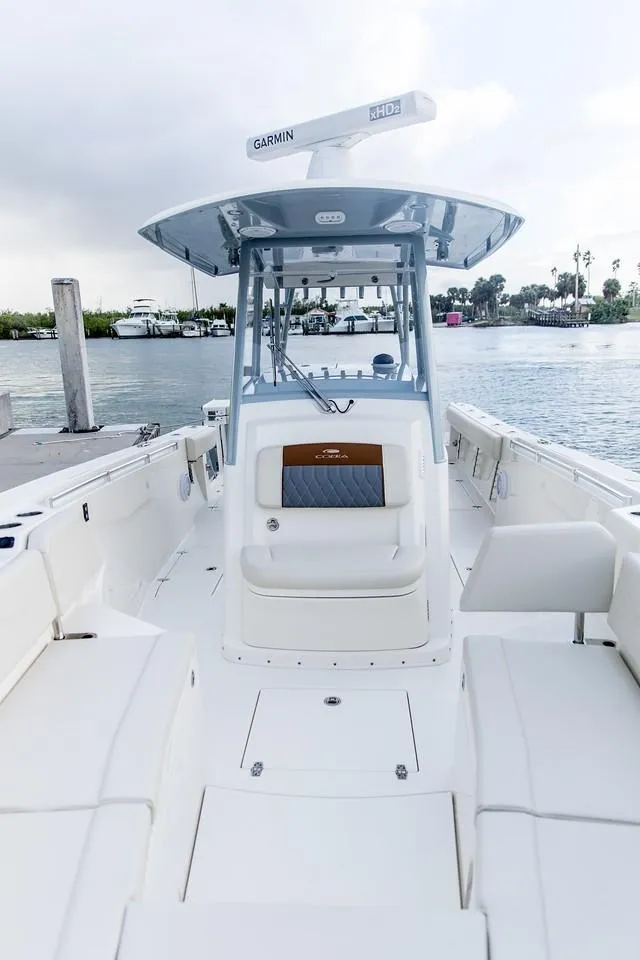 Slide: The Image of 2024 Cobia 320 CC center console boat docked by the water. - 8