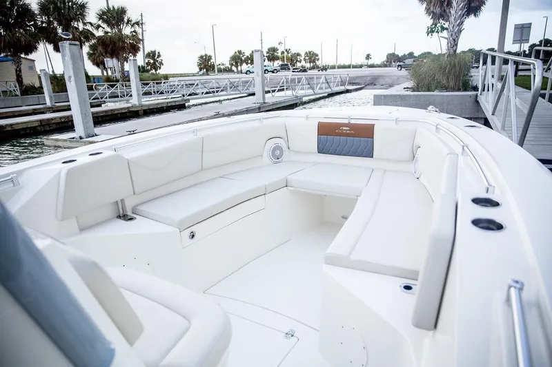 Slide: The Image of 2024 Cobia 320 CC boat with spacious seating at the dock. - 9
