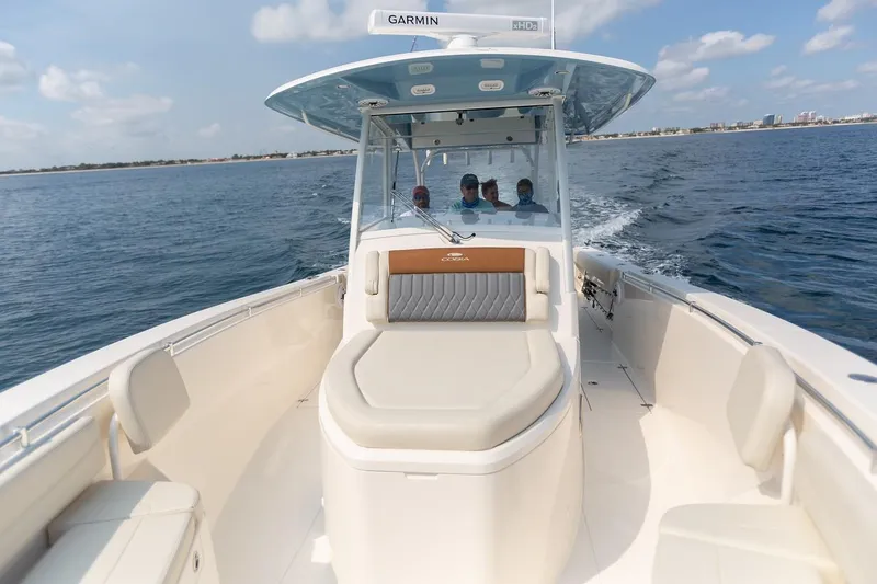 Slide: The Image of 2024 Cobia 350 CC boat cruising on open water with passengers. - 13