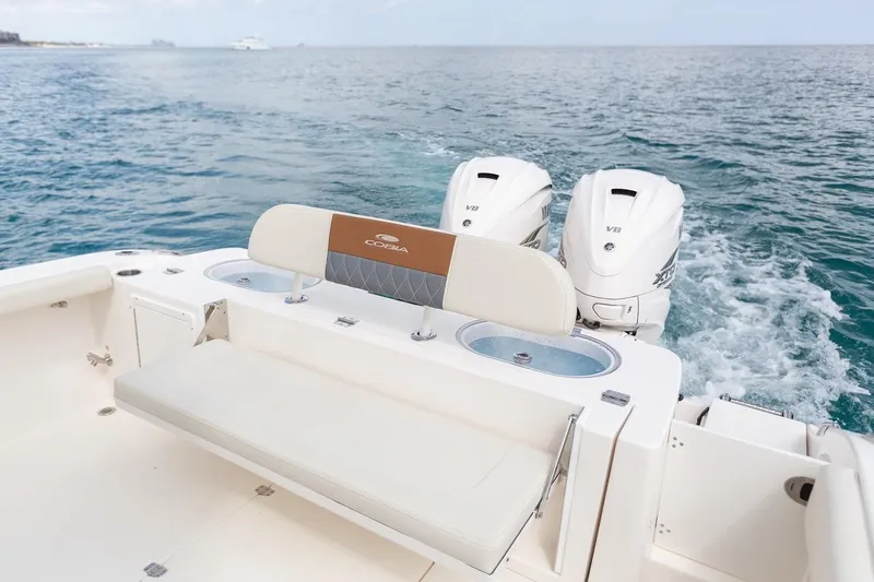 Slide: The Image of 2024 Cobia 350 CC boat with twin outboard engines on open water. - 14